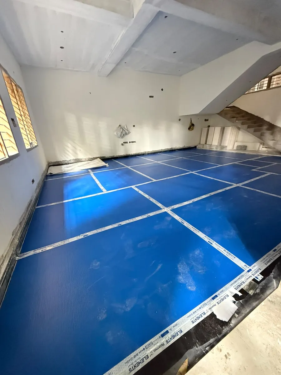 Roll of blue floor protection sheet being unrolled across a floor